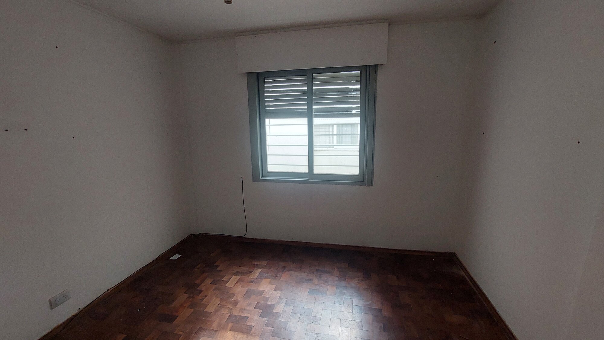 Dormitorio con parquet y ventana